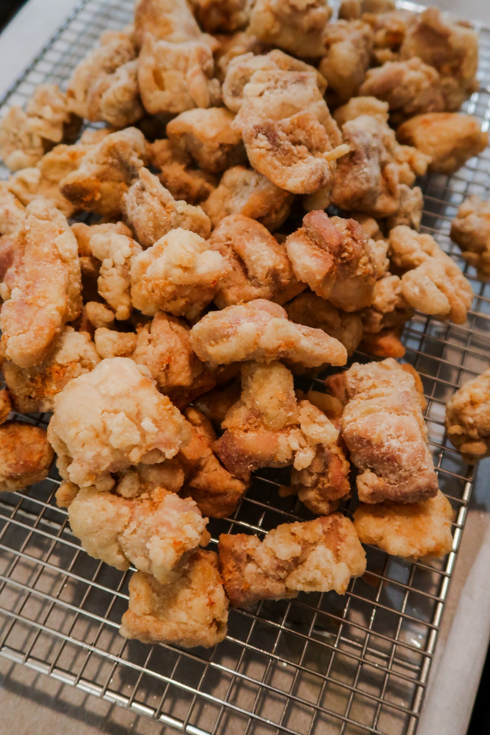 Gluten Free Fried Chicken is on a wire cooling rack to drain excess oil
